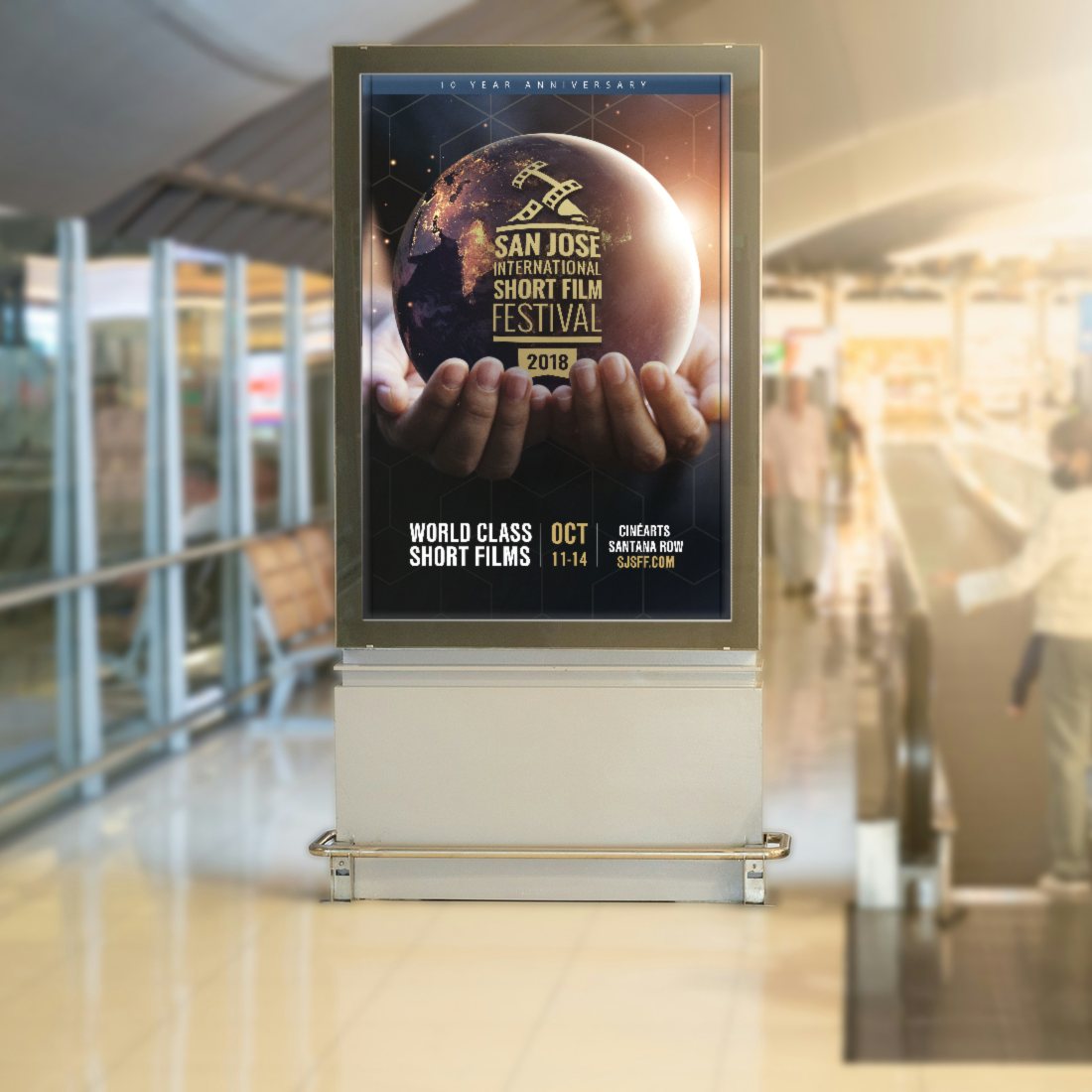 The 2018 San Jose International Short Film Festival 10th anniversary poster in a backlit lightbox in a busy terminal