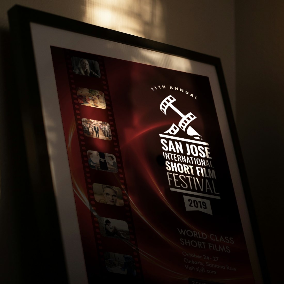 The 2019 San Jose International Short Film Festival poster in a black frame leaning in warm window light