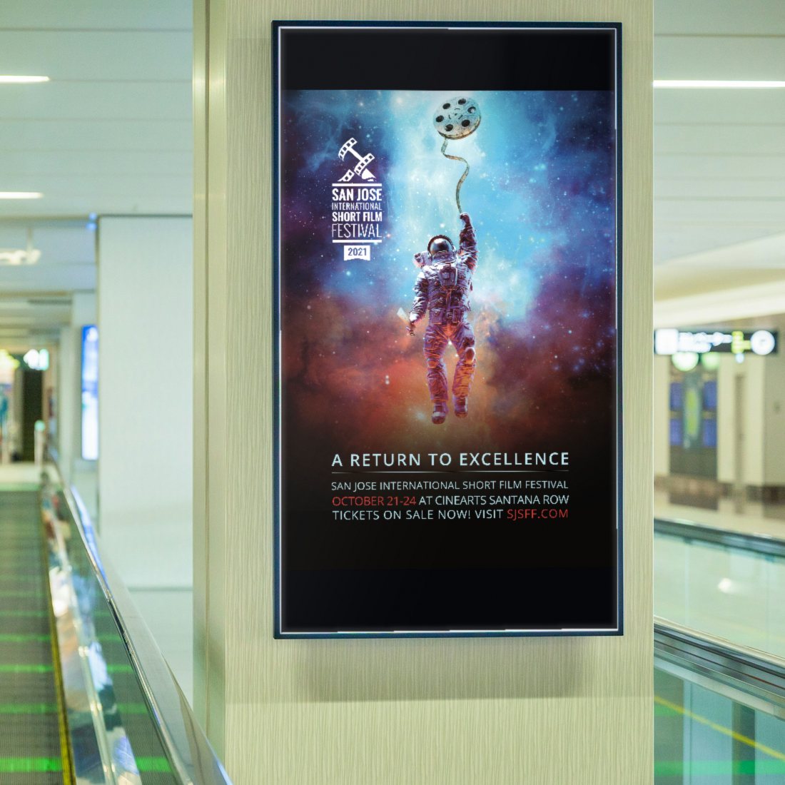 The 2021 San Jose International Short Film Festival “A Return to Excellence” poster on a digital screen beside a moving walkway