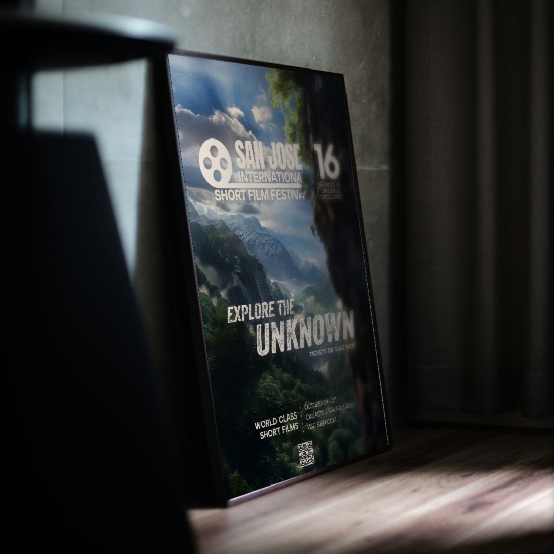 The 2024 San Jose International Short Film Festival “Explore the Unknown” poster in a black frame leaning against a wall in a dimly lit room