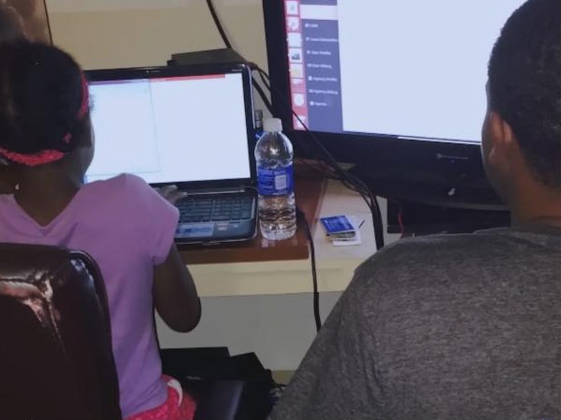 Young students learning to code on laptops in Generation Impact: The Coder