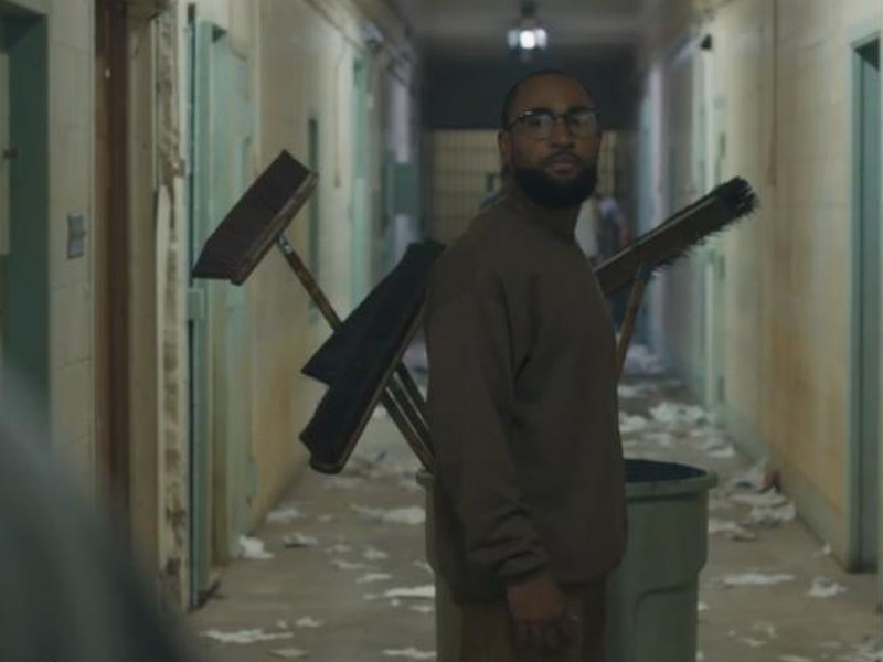 An inmate with a cleaning cart in a prison hallway in Infraction