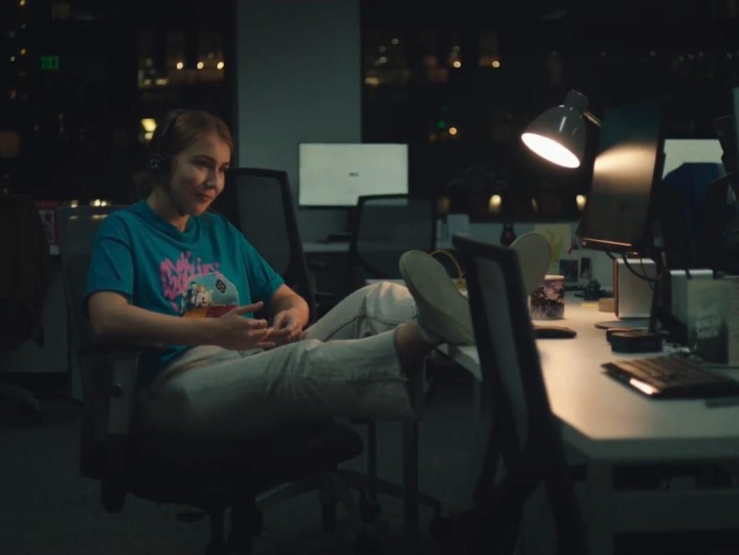 Leah leans back at her desk in a dark office in Rachels Don’t Run